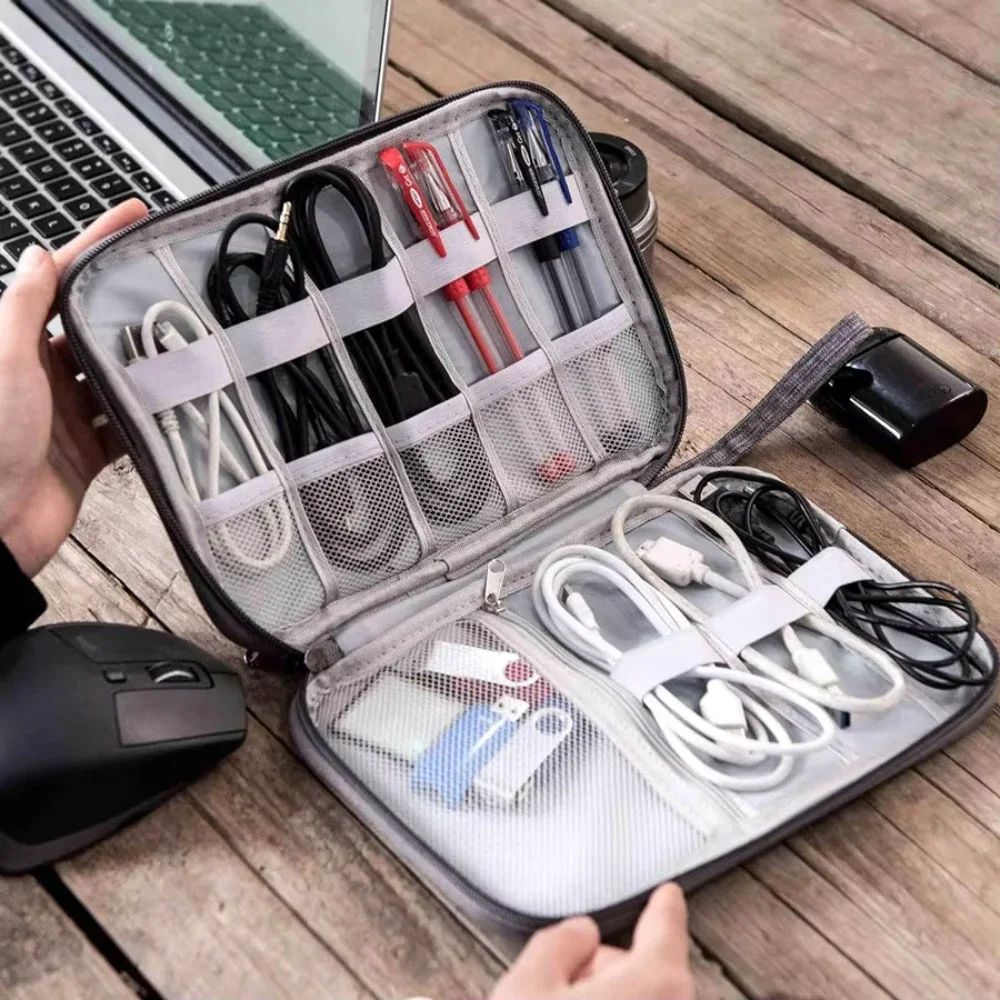 Organized travel case with electronic accessories on a wooden surface
